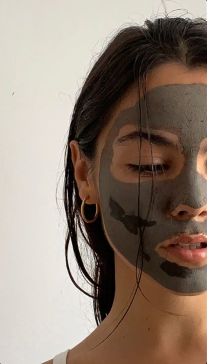 Person wearing a gray facial mask against a white background